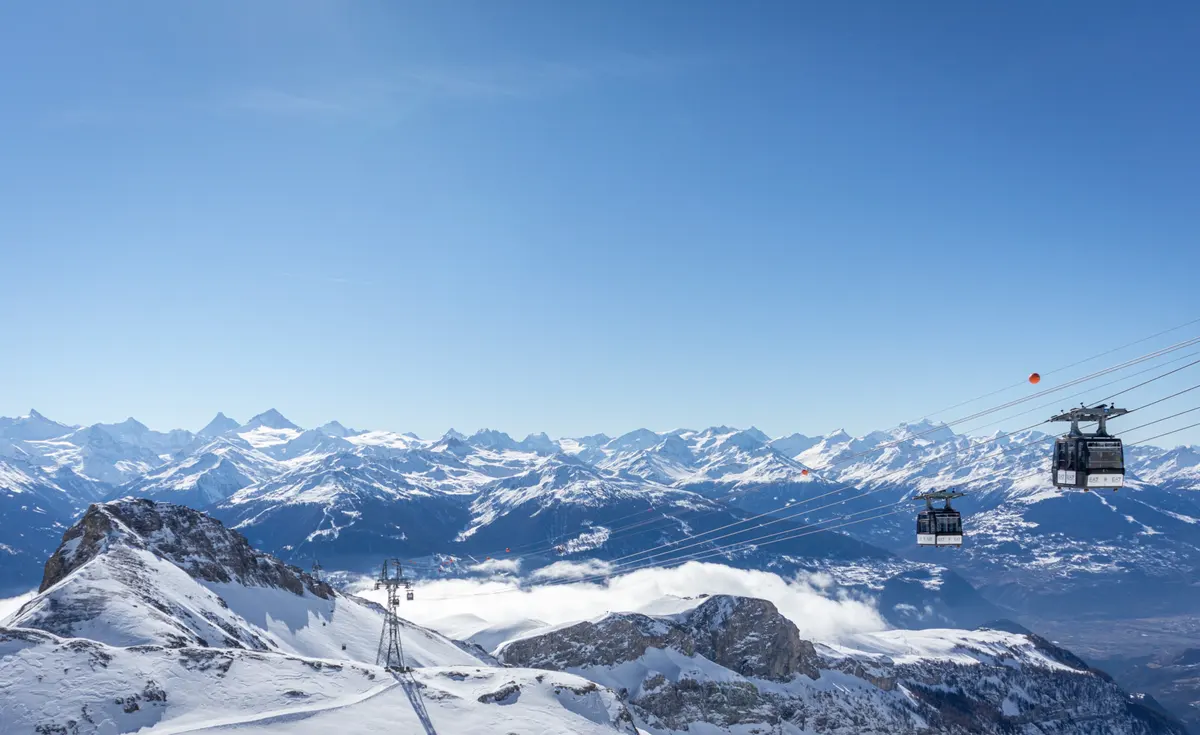 Taxi Crans-Montana – Vue sur les Alpes et téléphériques Vue panoramique de Crans-Montana avec les Alpes suisses et téléphériques en hiver